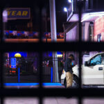 A armed private security guard on his phone inside a fenced off gas station on Lake Street in South Minneapolis.