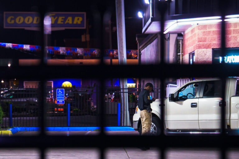 Private Security at Minneapolis Gas Station 3 A armed private security guard on his phone inside a fenced off gas station on Lake Street in South Minneapolis.