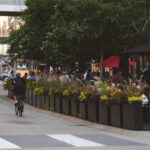 A Thursday evening on Nicollet Mall. Biker passes by The Local restaurant patio at 10th Street. (Downtown Minneapolis, September 2024)