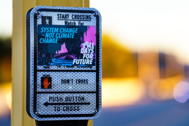 Minneapolis Uprising Sticker: System Change - Not Climate Change 1 A sticker reading "System Change - Not Climate Change" and "All Days For Future" is affixed to a pedestrian crossing signal in Minneapolis. The sticker reflects sentiments expressed during the Minneapolis Uprising, a period of civil unrest and protest that followed the murder of George Floyd in May 2020. The slogan "System Change - Not Climate Change" suggests a critique of broader societal structures, linking environmental concerns to systemic issues. The "All Days For Future" portion likely references climate activism, such as the Fridays for Future movement, indicating a connection between social justice and environmental justice.