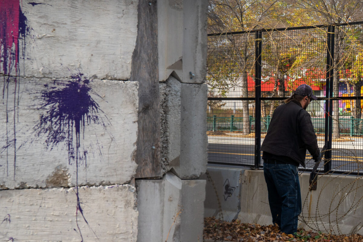 A man removes razor wire from the Minneapolis police third precinct police station. The razor wire was installed on the burned police station during the Derek Chauvin murder trial. The city says it'll be taking the concrete barricades down and replacing it with typical fabric lined construction fencing. The building, which was famously burned by protesters following the murder of George Floyd, is being redeveloped into a "Democracy Center" that'll be home to the city's election services and community use.