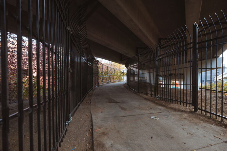 Walkway between fencing under I-94 2 New fencing dropped in the North Loop on N 5th Ave and I-94. It's too bad, was a fun spot to watch trains. Could see the Light Rail, Northstar Line and freight trains from under this bridge.