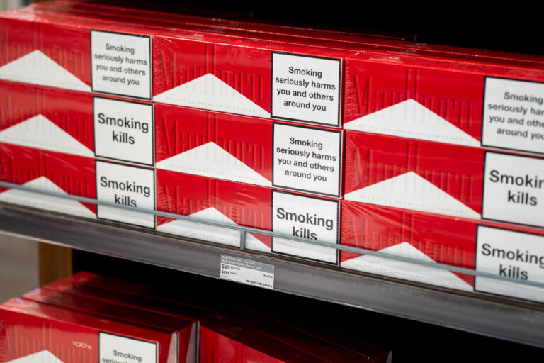 Duty-Free Display of Marlboro Cigarettes at Puerto Vallarta Air 2 Stacks of Marlboro cigarette cartons are arranged neatly in a duty-free shop at Puerto Vallarta International Airport. The bold red-and-white packaging contrasts sharply with the health warnings — “Smoking kills” and “Smoking seriously harms you and others around you.” The display, priced in both U.S. dollars and pesos, reflects international tobacco regulations that require prominent labeling even in airport retail environments catering to travelers.