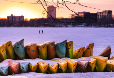 Canoes and kayaks stacked up in the snow around Bde Maka Ska.