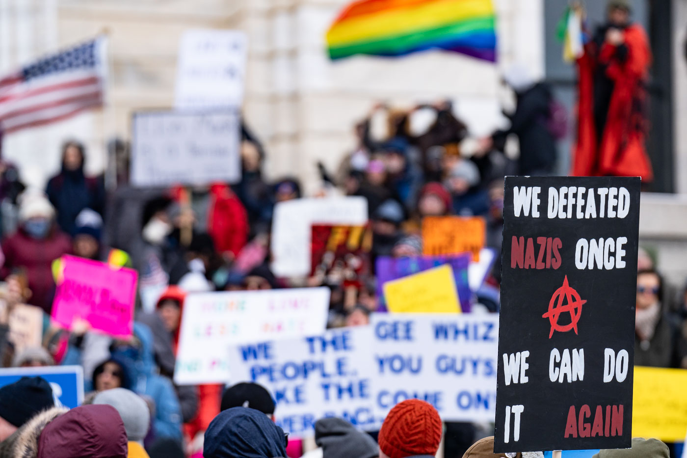 Protester at the Minnesota State Capitol on February 5, 2025 holding up a sign that reads "We defeated nazis once we can do it again".