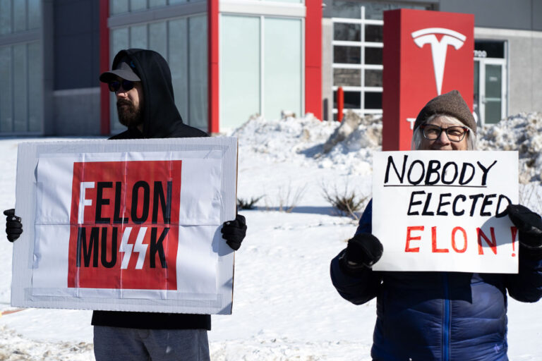 Nobody Elected Elon! Tesla Minneapolis Protest February 22, 2025 3 Protesters hold up signs that read "Felon MuSSK" "Nobody Elected Elon!" at a "Tesla Takedown" protest in front of a Tesla facility in Minneapolis on February 22, 2025.