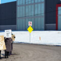 Protesters hold up signs reading "No Kings (Except Drag Kings) "Reminder: Nazi's Are Bad" at a "Tesla Takedown" protest in front of a Tesla facility in Minneapolis on February 22, 2025.