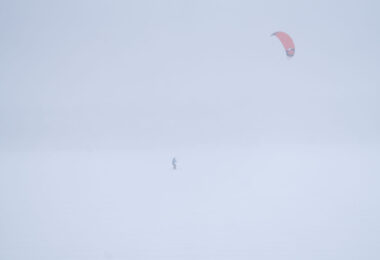 Someone snowkiting in Minneapolis on Bde Maka Ska during a February 2025 snowstorm.