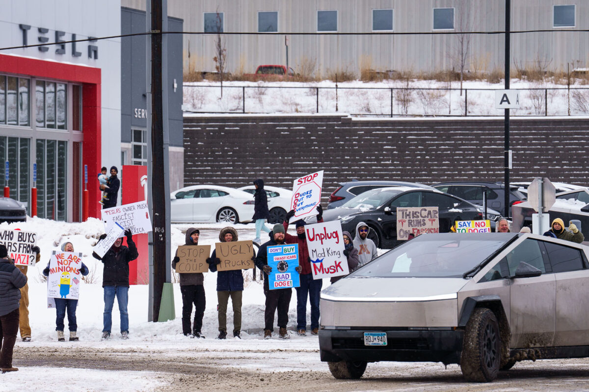 Protesters at the Tesla service center just outside of Minneapolis. Signs reading “Unplug Mad King Musk”, “This car runs on fascism”, “Who buys cars from a nazi?”, “Say no to doge”, “Don’t buy swasticars, BAD DOGE!”. Protest is part of a nationwide "TeslaTakedown" protest that seems to have originated on Bluesky.