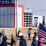Protester with an American flag outside a Tesla facility just outside of Minneapolis.