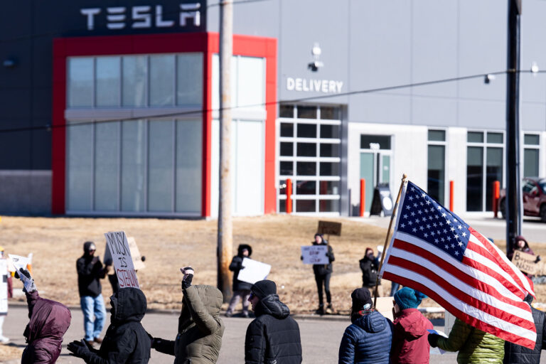 American Flag at Tesla Minneapolis 3 Protester with an American flag outside a Tesla facility just outside of Minneapolis.