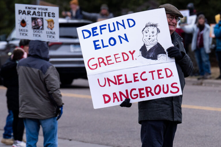 Defund Elon Greedy Unelected Dangerous protest sign in MN 1 About 500 protesters outside Tesla in Minneapolis (Golden Valley) with signs reading “NOT PAID JUST PISSED”, “Tesla Funds Fascists”, “Save the VA”, “No Vet Left Behind”, Make Nazis Afraid Again” to name a few. This is the 7th weekend in a row of protests at this showroom.