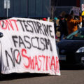 Large protest banner outside a Tesla facility in Minneapolis (Golden Valley) that reads:

"Don't testdrive fascism No Swasticar!"