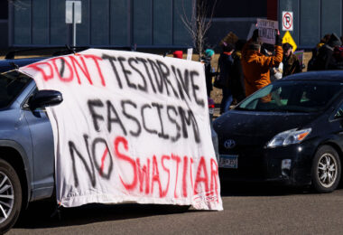 Large protest banner outside a Tesla facility in Minneapolis (Golden Valley) that reads:

"Don't testdrive fascism No Swasticar!"
