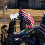 An upside down American Flag and a right side up American Flag seen outside a Tesla facility in Minneapolis (Golden Valley) on March 1, 2025. Protesters have been gathering for weeks now protesting the actions of Elon Musk and his Doge Department under the Trump administration.