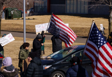 An upside down American Flag and a right side up American Flag seen outside a Tesla facility in Minneapolis (Golden Valley) on March 1, 2025. Protesters have been gathering for weeks now protesting the actions of Elon Musk and his Doge Department under the Trump administration.