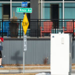 A man with a golf club and ball in Uptown Minneapolis on the first 60 degree day of the year.