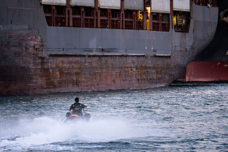 Jet Ski in Port of Miami 1 A man on a jet ski in the port of Miami text to large container ships.