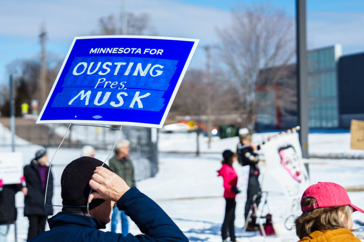 Protester with a sign reading "Minnesota for Ousting Pres. Musk" at a Tesla Facility just outside of Minneapolis (Golden Valley) on March 8, 2025.

This is the 4th week in a row protesters have gathered here as part of the nationwide Tesla Takedown organizing.