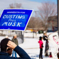 Protester with a sign reading "Minnesota for Ousting Pres. Musk" at a Tesla Facility just outside of Minneapolis (Golden Valley) on March 8, 2025.

This is the 4th week in a row protesters have gathered here as part of the nationwide Tesla Takedown organizing.