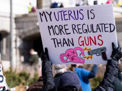 Protest sign reading my uterus is more regulated than guns