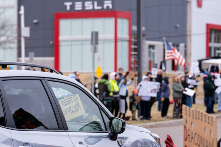 Resist Fascism Protest Sign 4 About 500 protesters outside Tesla in Minneapolis (Golden Valley) with signs reading “NOT PAID JUST PISSED”, “Tesla Funds Fascists”, “Save the VA”, “No Vet Left Behind”, Make Nazis Afraid Again” to name a few. This is the 7th weekend in a row of protests at this showroom.