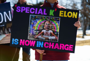 Protester holding a sign that reads "Special K Elon Is Now In Charge" at a Tesla Facility just outside of Minneapolis (Golden Valley) on March 8, 2025.

This is the 4th week in a row protesters have gathered here as part of the nationwide Tesla Takedown organizing.