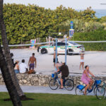 A Miami-Dade police squad car drives down the beach during a beach volleyball game during 2025 Spring Break in South Beach.