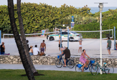 A Miami-Dade police squad car drives down the beach during a beach volleyball game during 2025 Spring Break in South Beach.