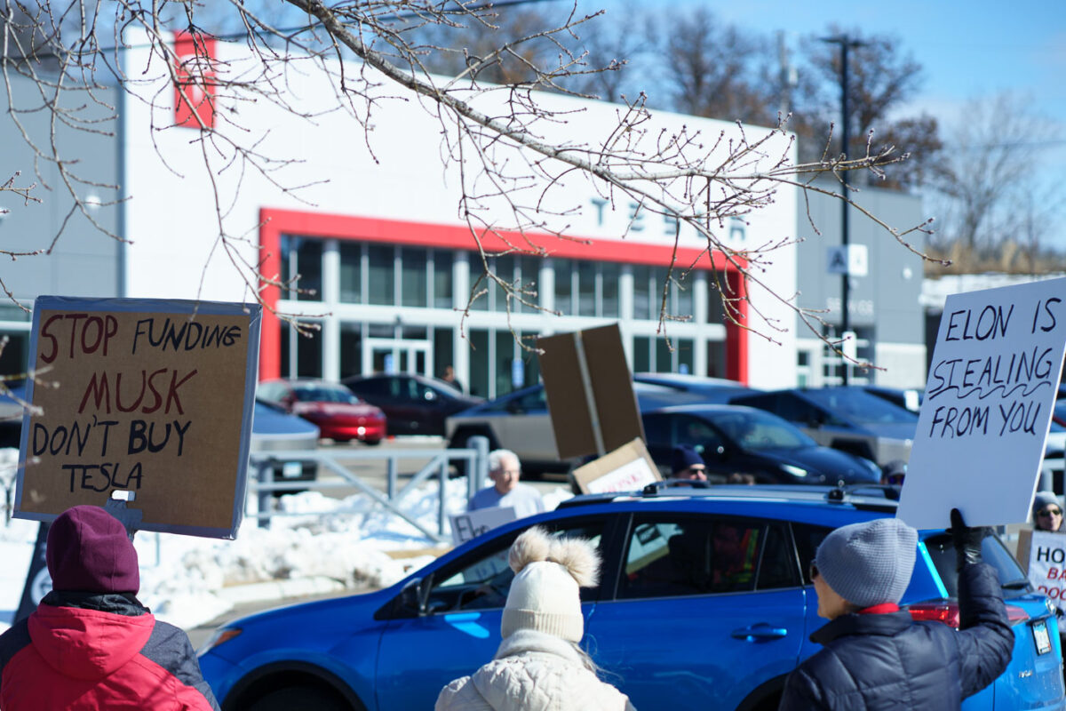 Protesters hold up signs outside a Tesla Facility just outside of Minneapolis (Golden Valley) on March 8, 2025.

This is the 4th week in a row protesters have gathered here as part of the nationwide Tesla Takedown organizing.