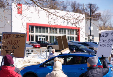 Protesters hold up signs outside a Tesla Facility just outside of Minneapolis (Golden Valley) on March 8, 2025.

This is the 4th week in a row protesters have gathered here as part of the nationwide Tesla Takedown organizing.