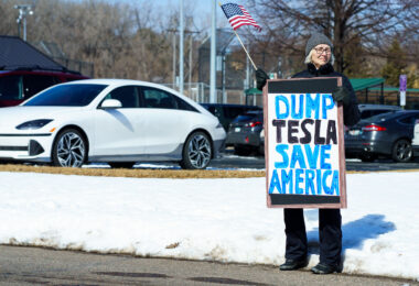 Protester holds a sign that reads "Dump Tesla Save America". Seen at a Tesla facility just outside of Minneapolis (Golden Valley) on March 8, 2025.

This is the 4th week in a row protesters have gathered here as part of the nationwide Tesla Takedown organizing.