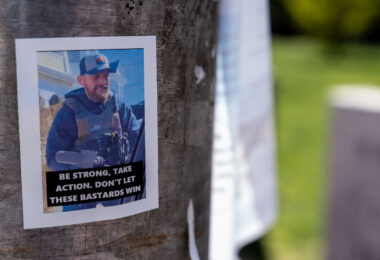 A wheat pasted poster on a pole that reads "Be strong, take action. Don't let these bastads win".