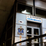 Bowdoin Station Elevator, Blue Line 1 An elevator entrance at Bowdoin station, the downtown terminal of Boston’s Blue Line. Bowdoin Station opened in 1916 as part of the East Boston Tunnel, one of the earliest underwater rapid-transit tunnels in North America. The station is notable for its compact footprint, tight curves, and historically limited accessibility compared to newer MBTA stations.This elevator provides step-free access between street level and the platform, reflecting later retrofits required by accessibility standards rather than original station design. The utilitarian signage, metal paneling, and enclosed structure are characteristic of mid-to-late 20th century upgrades layered onto early 20th century transit infrastructure, illustrating how legacy subway systems have been incrementally adapted to modern accessibility and safety requirements.