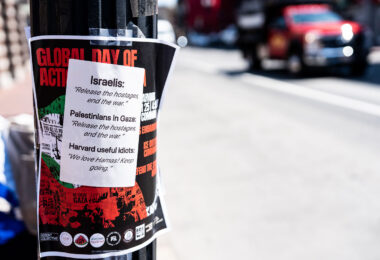 Protest flyers seen at Harvard University. This particular one covered with a "Harvard useful idiots" sticker.