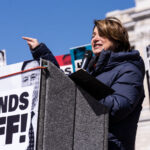 Amy Klobuchar speaking to a crowd of around 25,000 at a "Hands Off!" protest at the Minnesota State Capitol
