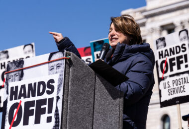 Amy Klobuchar speaking to a crowd of around 25,000 at a "Hands Off!" protest at the Minnesota State Capitol