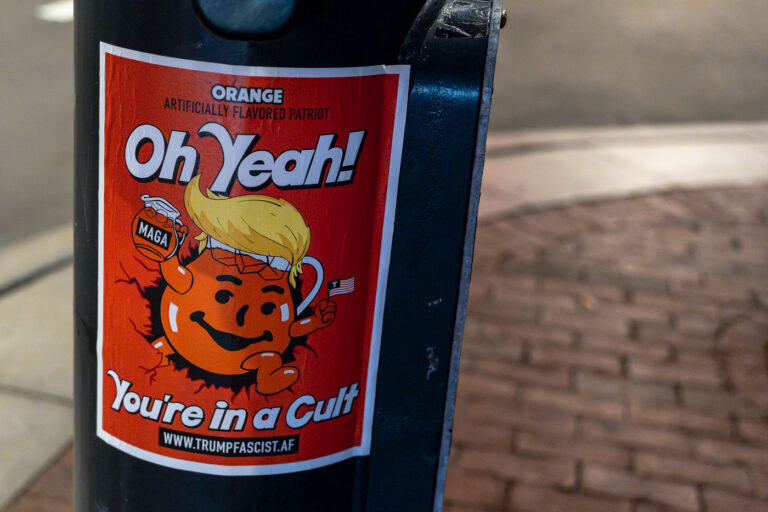 You're in a Cult Trump Fascist poster 3 Poster on a pole at Harvard University.You're in a Cult" in the form of the Kool-Aid man with a link that redirects to The Council on Foreign Relations's definition of fascism.