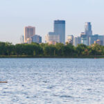A couple on Bde Maka Ska with the Minneapolis city skyline behind