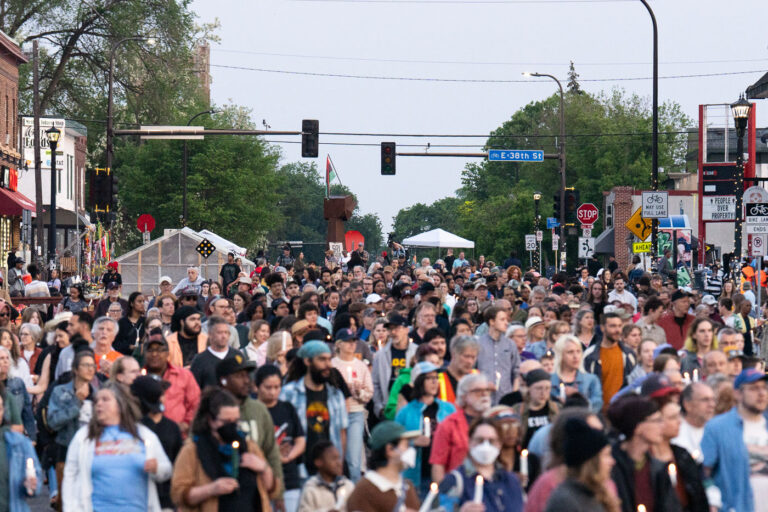 Fist at 38trh and Chicago on 5th anniversary 4 Candlelight vigil walks down Chicago Avenue away from the first towards Say Their Names Cemetery. The vigil happens each year on the 5th anniversary of George Floyd's murder.