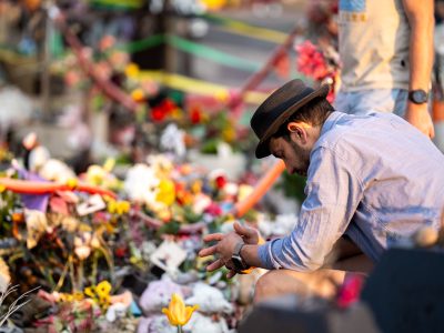 Man Kneels Among Flowers at George Floyd Square Memorial
