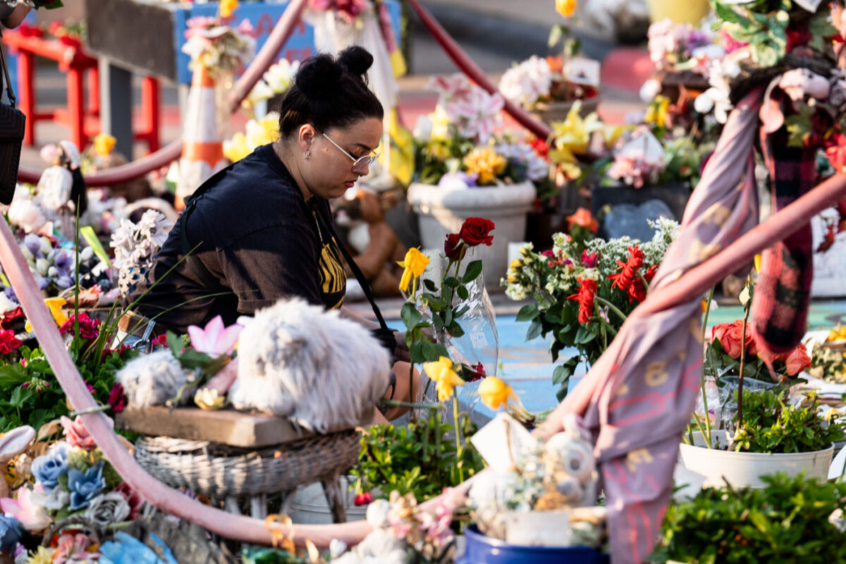 A woman lays a flower down on the 5th anniversary of George Floyd's murder. The site has been a place of protest since the 2020 murder.