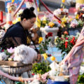 A woman lays a flower down on the 5th anniversary of George Floyd's murder. The site has been a place of protest since the 2020 murder.
