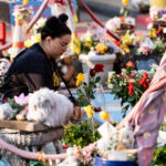 A woman lays a flower down on the 5th anniversary of George Floyd's murder. The site has been a place of protest since the 2020 murder.
