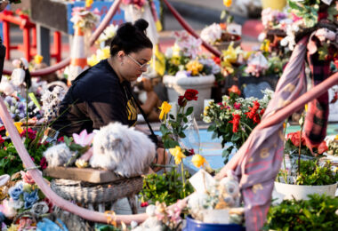 A woman lays a flower down on the 5th anniversary of George Floyd's murder. The site has been a place of protest since the 2020 murder.