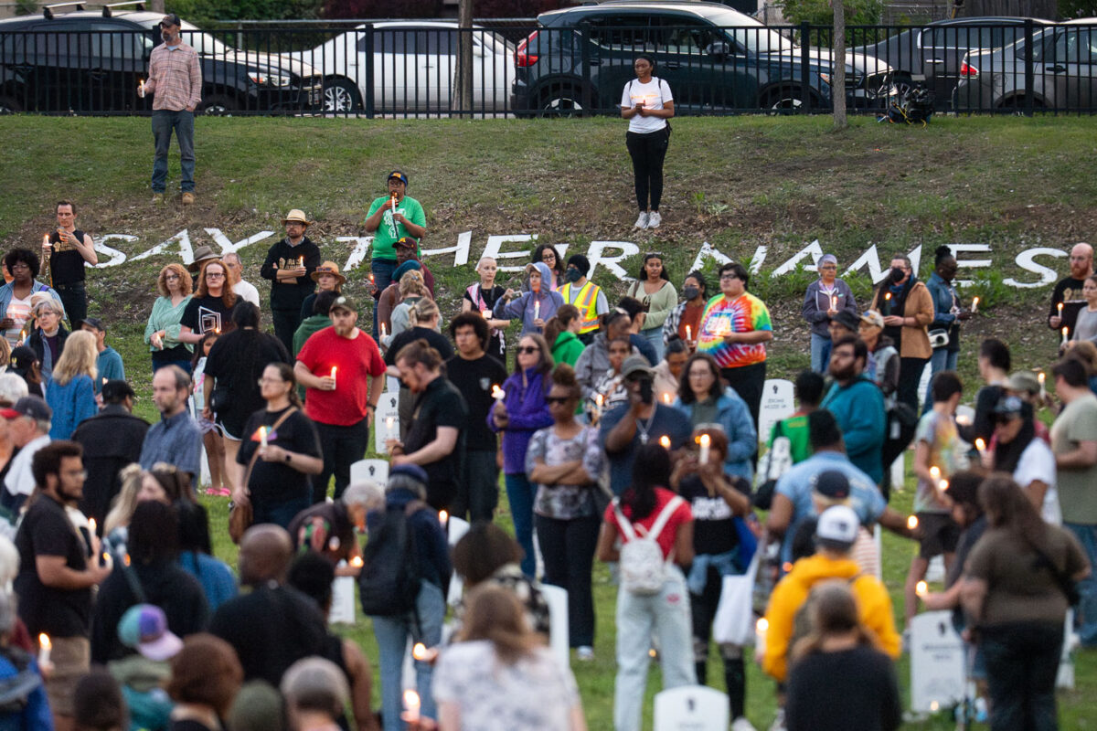 Jeanelle Austin and others hold candles at Say Their Names Cemetery on the 5th anniversary of George Floyd's murder.
