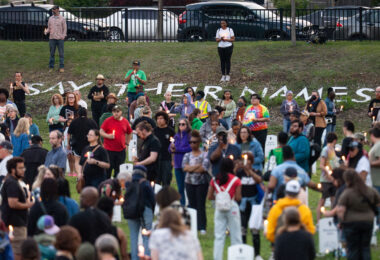 Jeanelle Austin and others hold candles at Say Their Names Cemetery on the 5th anniversary of George Floyd's murder.
