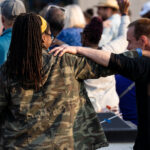 Marcia Howard and another man put their arms on each other during a performance on the Rise and Remember stage.