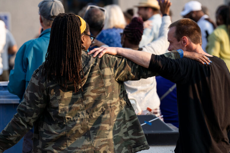 Marcia Howard at Rise and Remember Festival 1 Marcia Howard and another man put their arms on each other during a performance on the Rise and Remember stage.