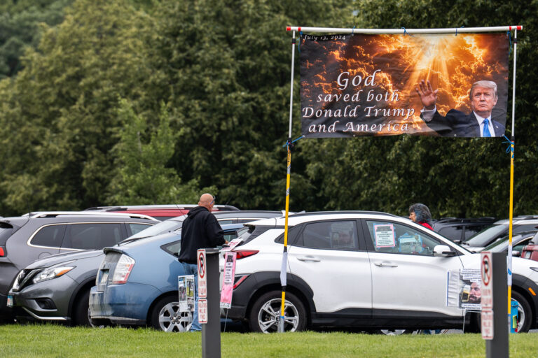 God Saved Both Donald Trump and America Sign 1 A sign put up outside a Tesla dealership in Minneapolis on June 14, 2025.